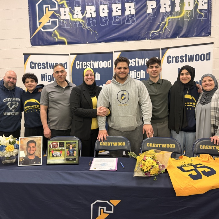 Hussein Ajrouche and family stand at the signing table
