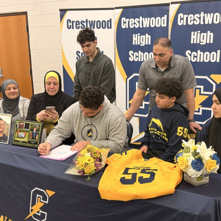 Hussein finishes signing as family looks on