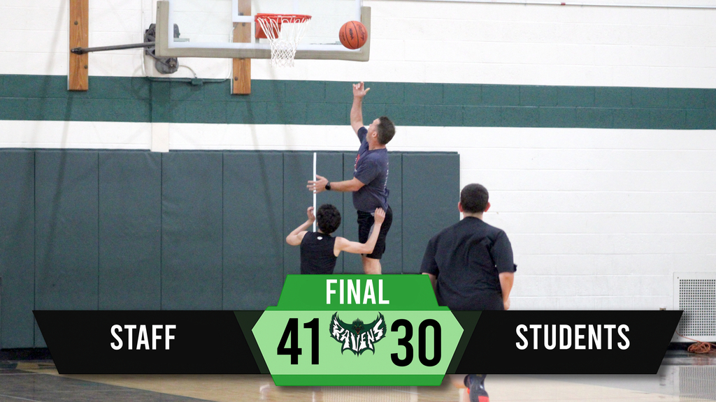 An indoor basketball game with a player in midair aiming to score. The score shows 41 for staff and 30 for students.