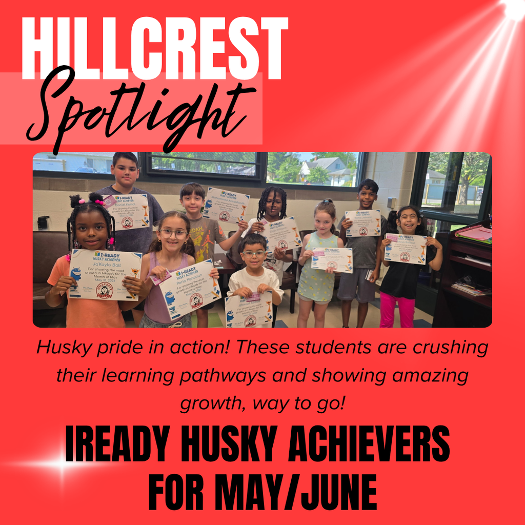 A bright red school recognition graphic titled “HILLCREST Spotlight” appears at the top left. The word “HILLCREST” is displayed in very large white block letters, while the word “Spotlight” is written below in large black cursive script over a lighter red rectangular background. White spotlight beams shine diagonally from the upper right corner across the background, and a glowing white sparkle effect appears near the lower left corner.  Centered on the graphic is a large group photograph of elementary school students standing indoors and proudly holding achievement certificates and recognition slips. The students are arranged in two rows and smile toward the camera while displaying their awards. The certificates are titled “i-READY HUSKY ACHIEVERS” and recognize student growth and achievement. Large classroom windows behind the students show trees, houses, and parked cars outside, while classroom furniture and shelves are visible along the right side of the room.  Below the photograph is black italicized text that reads: “Husky pride in action! These students are crushing their learning pathways and showing amazing growth, way to go!”  At the bottom of the graphic, very large bold black block letters read: “IREADY HUSKY ACHIEVERS FOR MAY/JUNE.”  The overall design uses a celebratory school spotlight theme with bright red coloring, dramatic white light beams, and student achievement recognition imagery highlighting Hillcrest Elementary students’ academic growth and success in i-Ready during May and June.