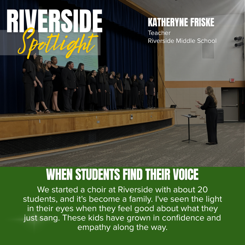 A promotional graphic titled “RIVERSIDE Spotlight” features a photograph of a middle school choir performing on stage during a concert rehearsal or performance. The word “RIVERSIDE” appears in large white capital letters in the upper left corner, with the word “Spotlight” written beneath it in large yellow script over a semi-transparent gray rectangle. In the upper right corner, white text reads: “KATHERYNE FRISKE” followed by “Teacher” and “Riverside Middle School.”  The main photograph shows approximately 15 middle school students standing in a choir formation across a stage, all dressed in black concert attire. The students are facing forward with attentive posture as they sing. In front of the stage, a teacher stands with her back and side partially facing the camera, conducting the choir with both hands raised. A black music stand is positioned in front of the conductor. The stage features dark blue curtains and a wooden front edge, while a projected presentation is faintly visible on a screen behind the choir. The auditorium includes a gray carpeted floor, light-colored walls with wood accents, mounted stage lighting, and an exit door visible on the right side. Soft rays of light shine from the upper right corner of the graphic, adding emphasis to the performance scene.  Across the bottom of the photograph, large white capital letters read: “WHEN STUDENTS FIND THEIR VOICE.”  The bottom third of the graphic is a dark green panel containing centered white text that reads: “We started a choir at Riverside with about 20 students, and it's become a family. I've seen the light in their eyes when they feel good about what they just sang. These kids have grown in confidence and empathy along the way.”  The overall design combines a live performance photograph with bold typography and green accents to recognize Katheryne Friske of Riverside Middle School while highlighting the positive impact of choir on students' confidence, sense of belonging, empathy, and personal growth.