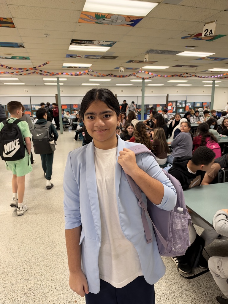 Student dressed as a teacher holding a backpack.