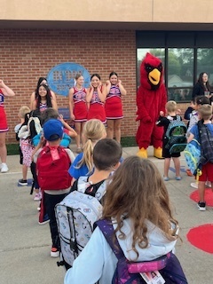Cheerleaders and mascot playing with students