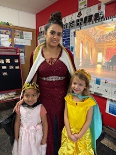 Teacher and two students wearing crowns.