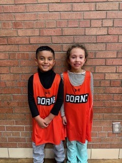 Two students standing by each other. 