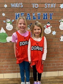 Two students standing by each other. 