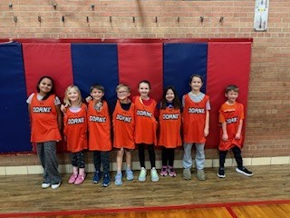 Second grade students standing by each other. 