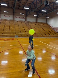 Boy holding a paddle hitting a balloon. 