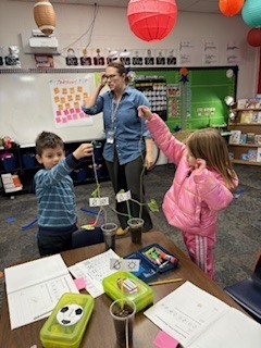 Two students holding up a plant. 