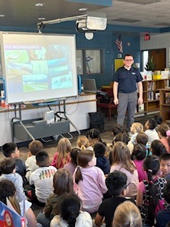 A man talking to a group of students. 
