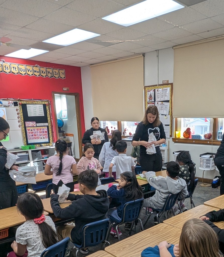 Students and adults in a classroom learning about dental hygiene.