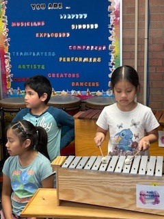 Student playing music instrument. 