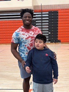 Two students standing by each other.