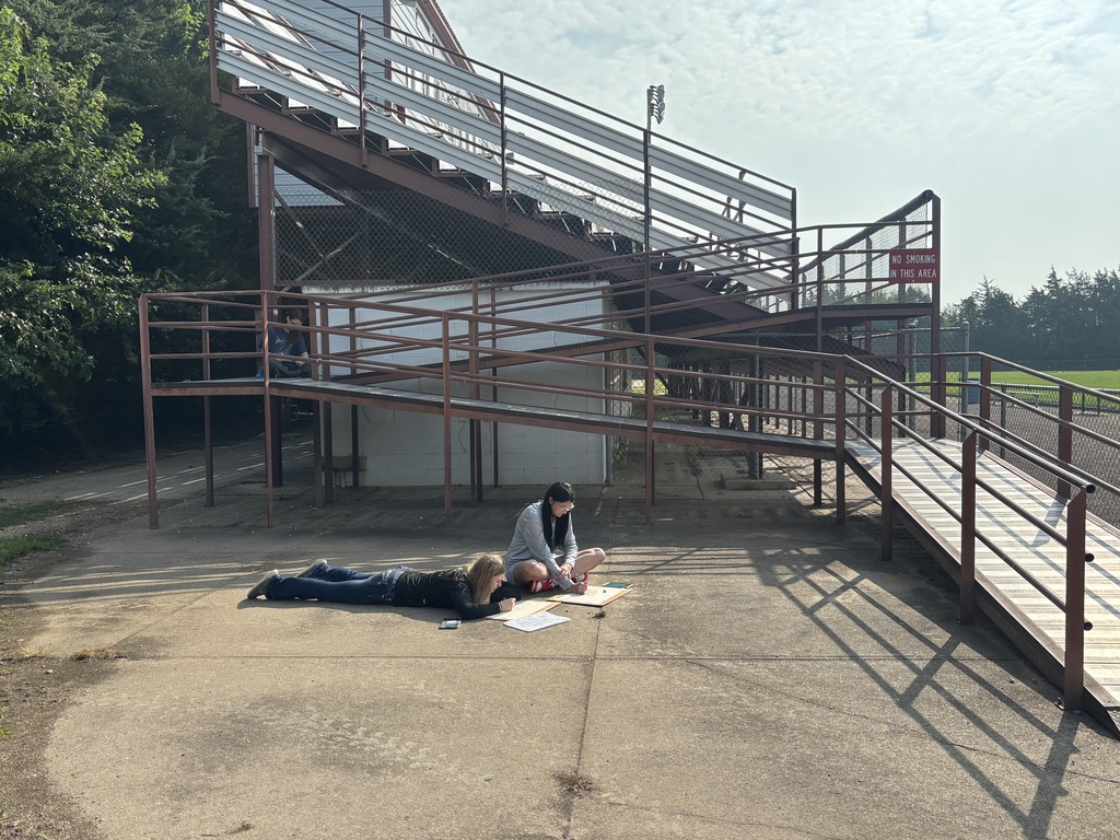 Three students working on their drawings. Sierra and Aven are drawing a rock, while Lukas works digitally to depict his image.