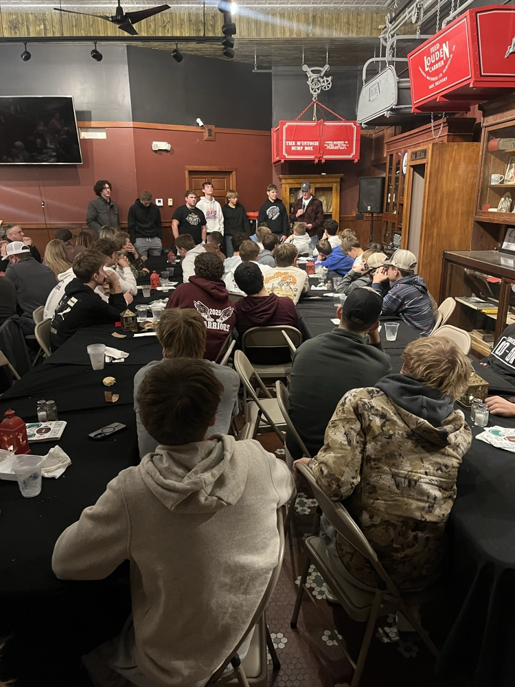 senior football players talking at the team meal