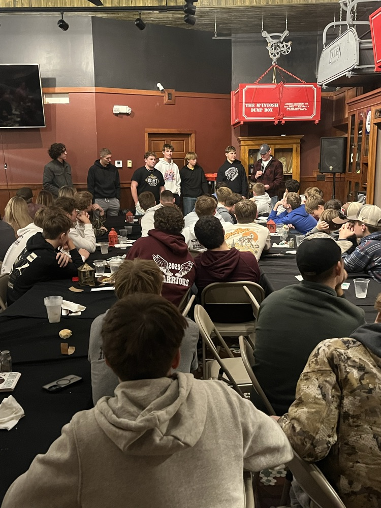 senior football players talking at the team meal
