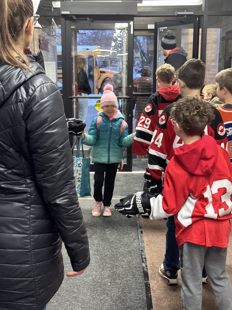 Team giving fives to elementary students