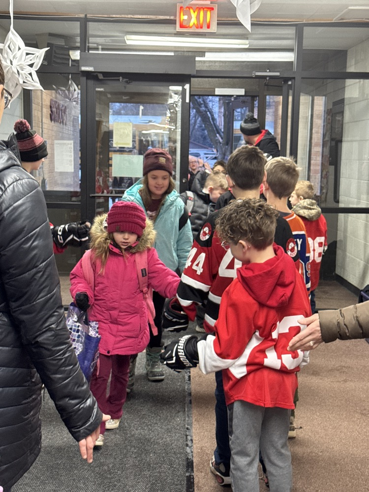 Team giving fives to elementary students