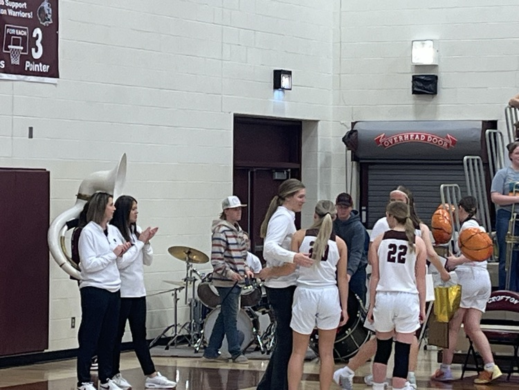 3 Senior girls giving Coach Moon a gift