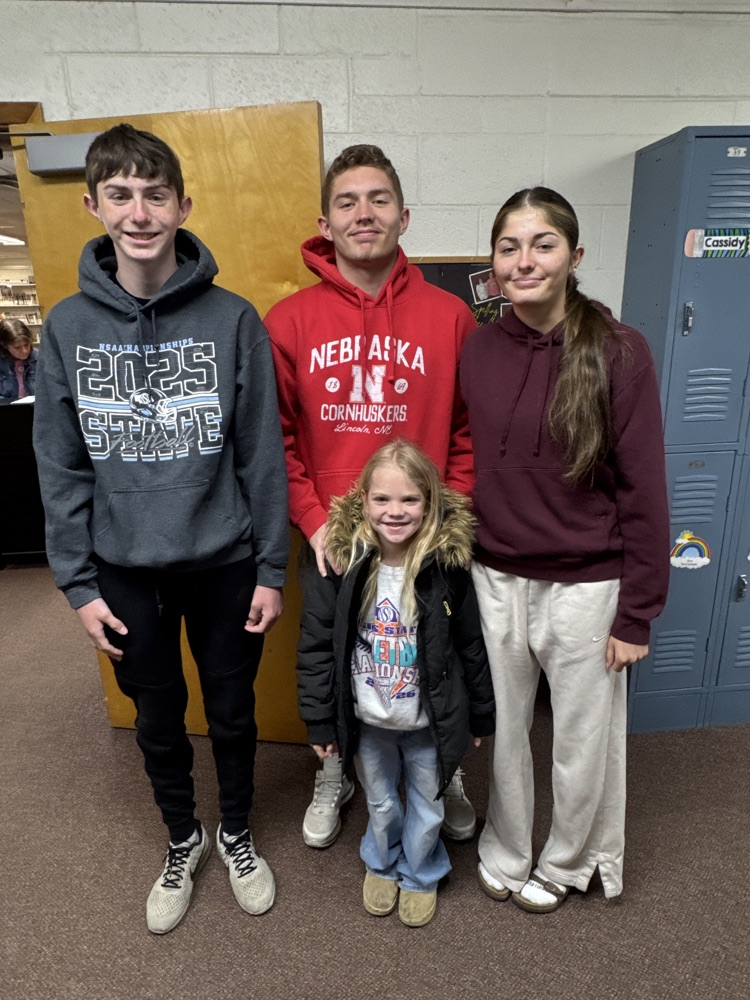 Students posing with their siblings on the track team at High Five Friday