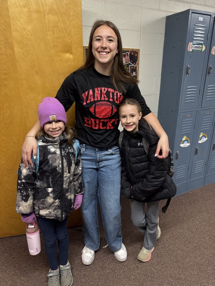 Students posing with their siblings on the track team at High Five Friday