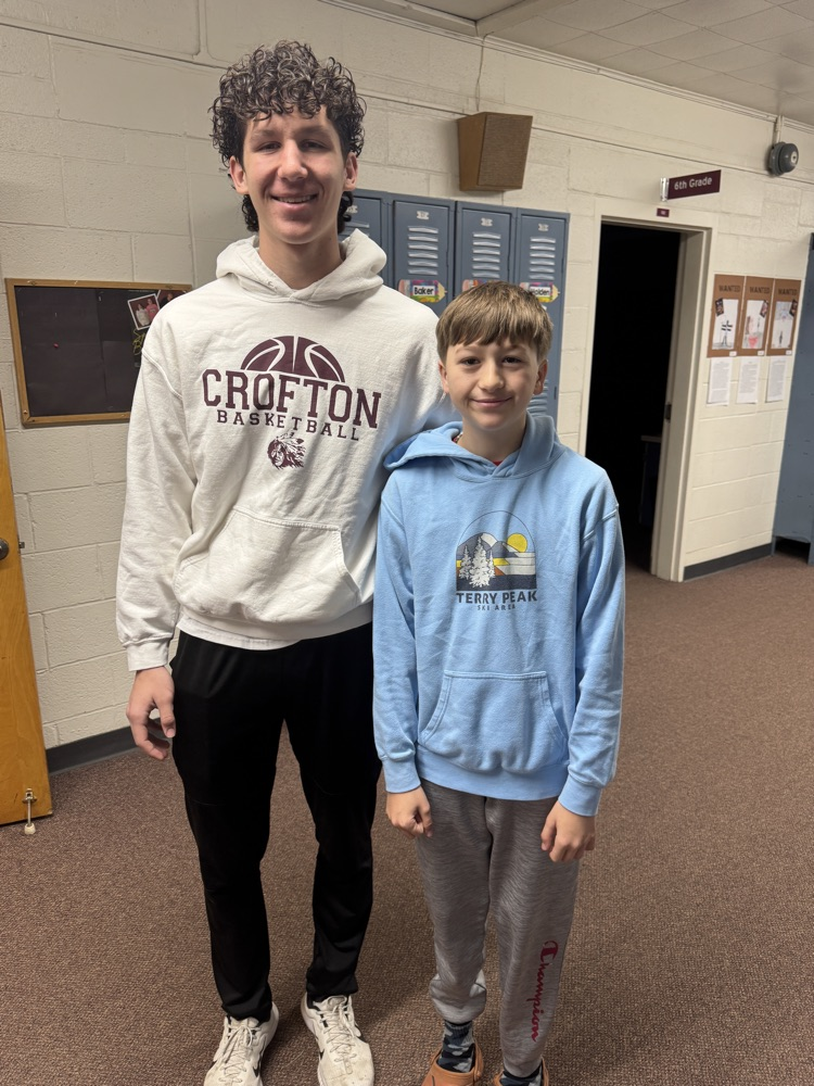 Students posing with their siblings on the track team at High Five Friday