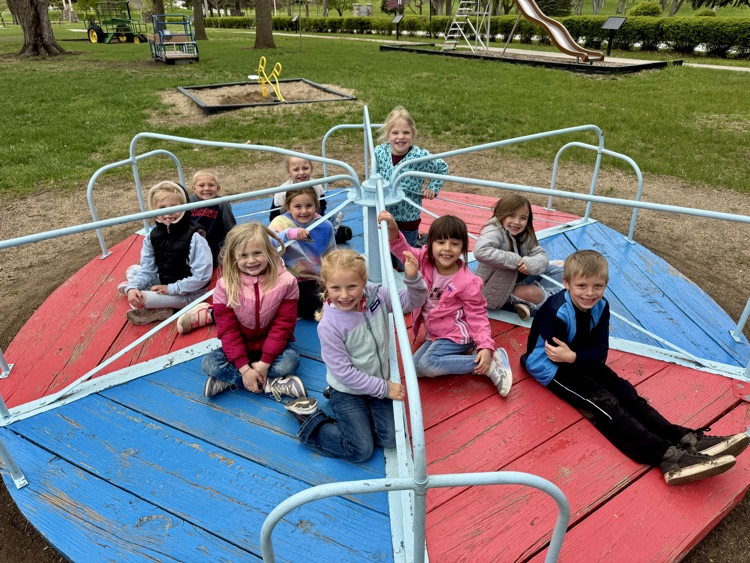 Kindergarteners enjoying the merry-go-round at Felber Park during lunch 