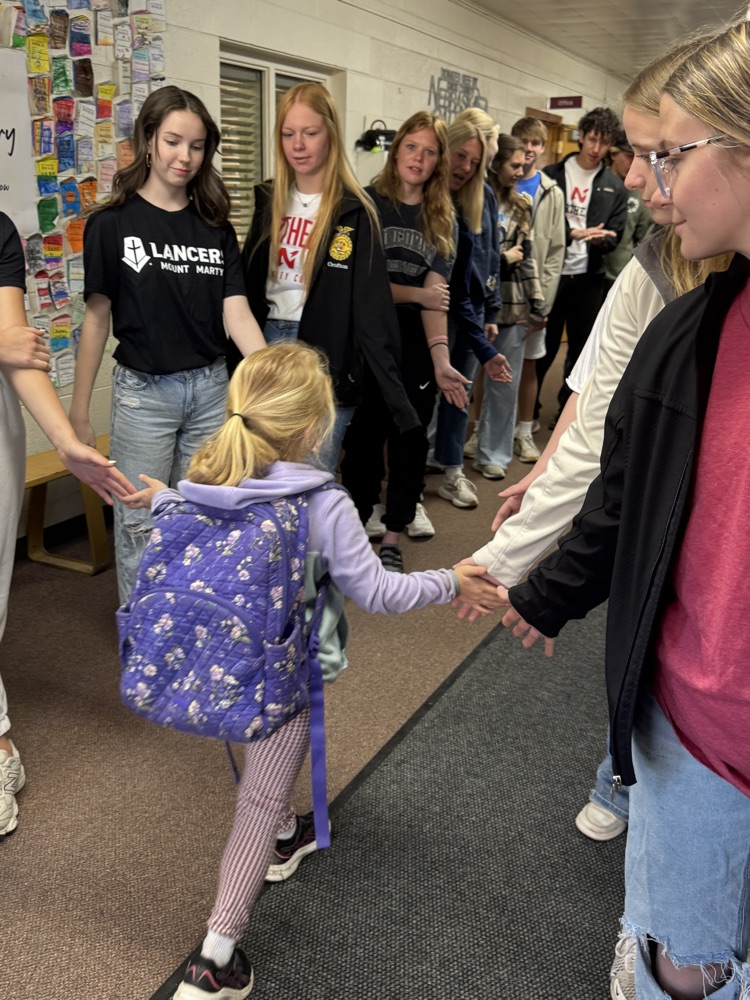 Members of the senior class at the elementary school for High Five Friday giving students high fives
