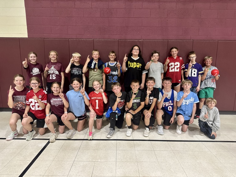 6th graders posing for a photo after winning the Dodgeball contest against the teachers 