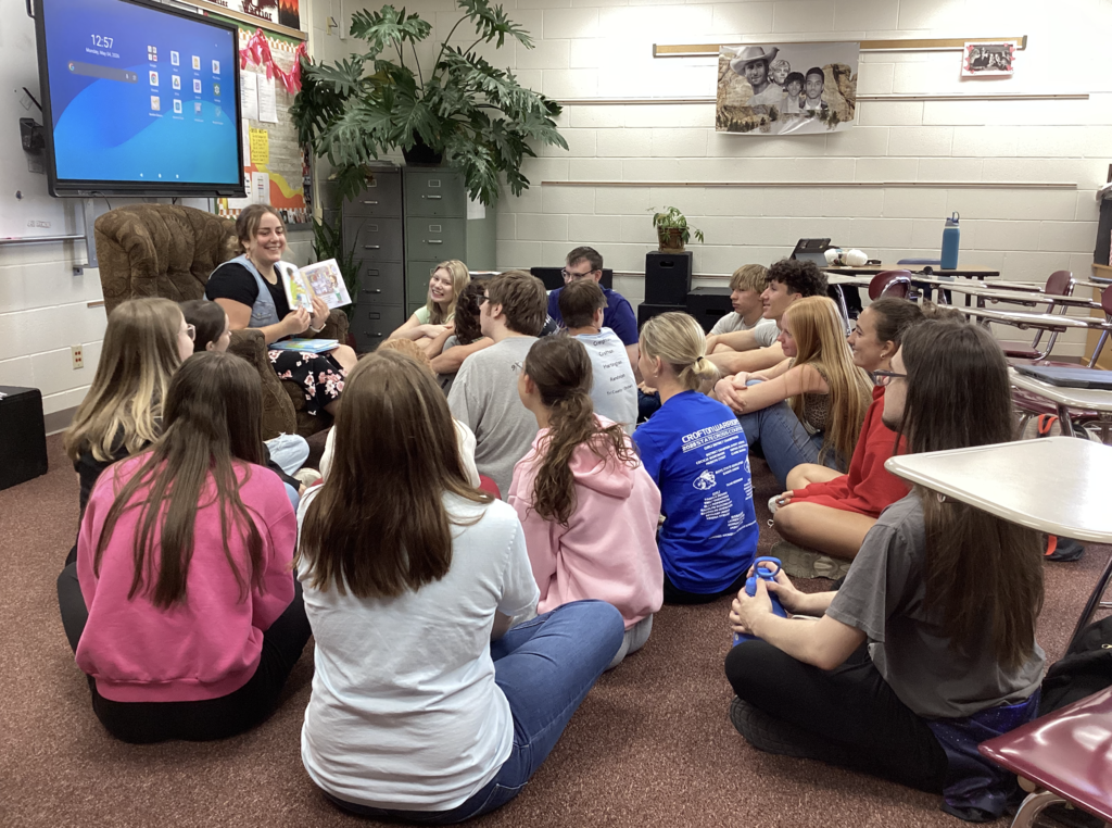 Seniors sitting in a circle listening to a book being read to them