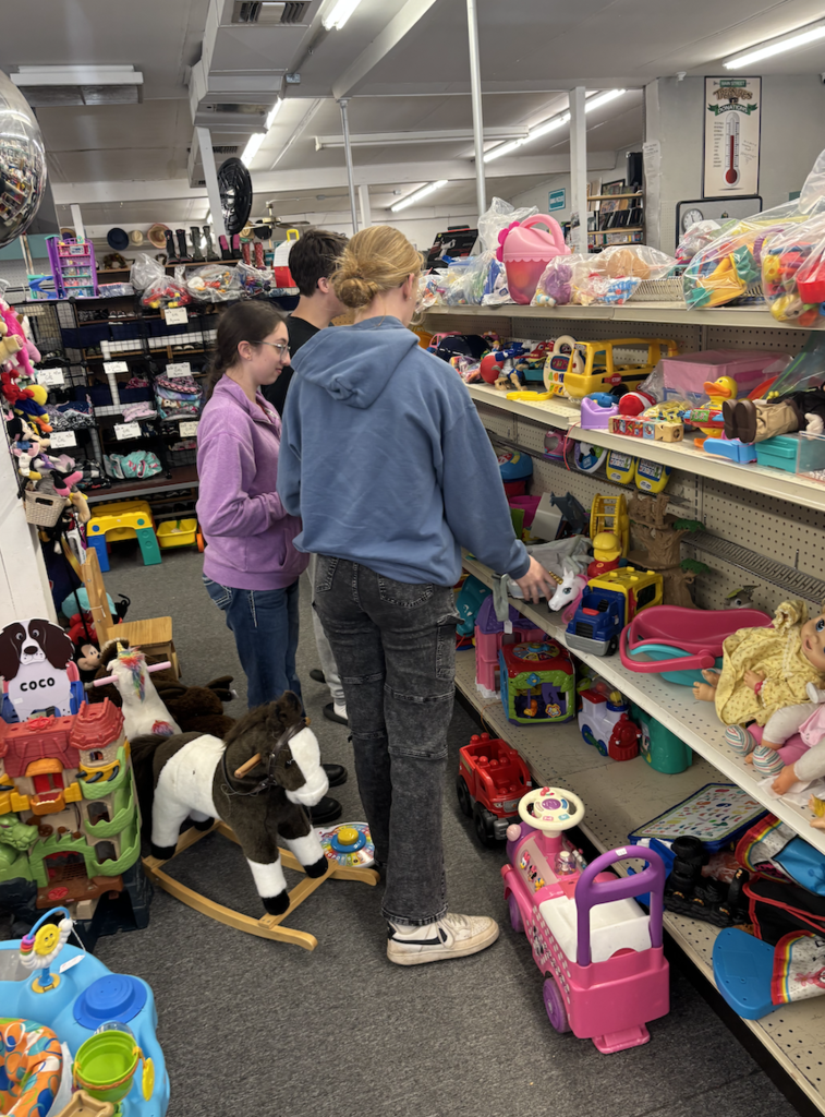 Lilly, Ben, and Brooklynn looking for items in the thrift store. 