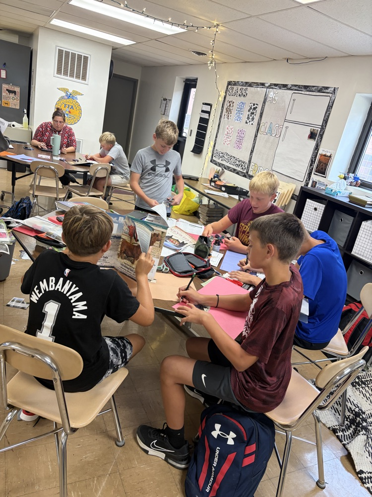 Students searching magazines for examples.