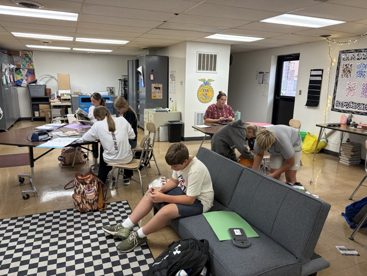 Students searching magazines for examples.