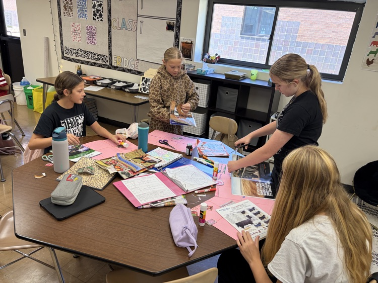 Students searching magazines for examples.