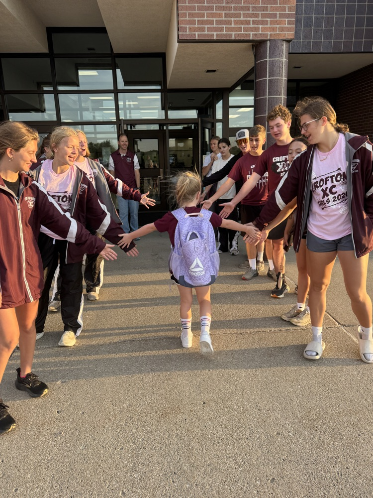 Cross Country team giving high fives to students at High Five Friday 