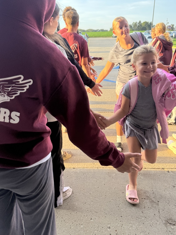 Cross Country team giving high fives to students at High Five Friday 