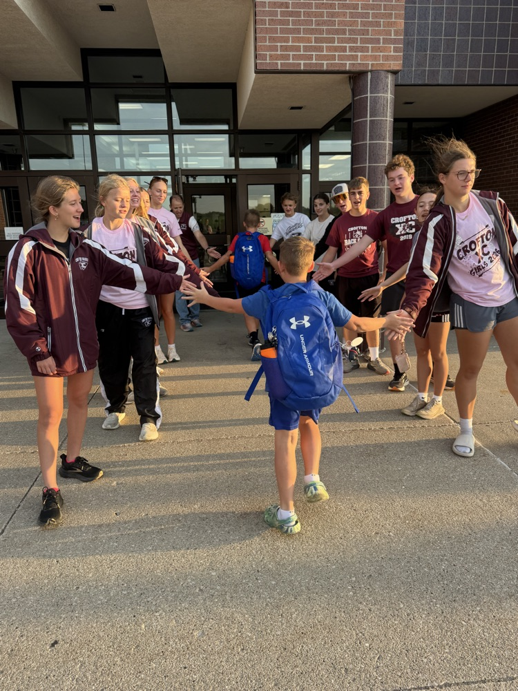 Cross Country team giving high fives to students at High Five Friday 