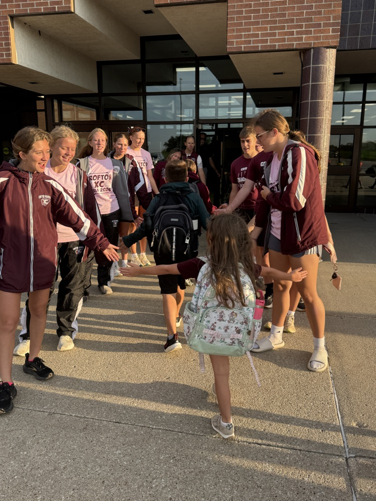 Cross Country team giving high fives to students at High Five Friday 