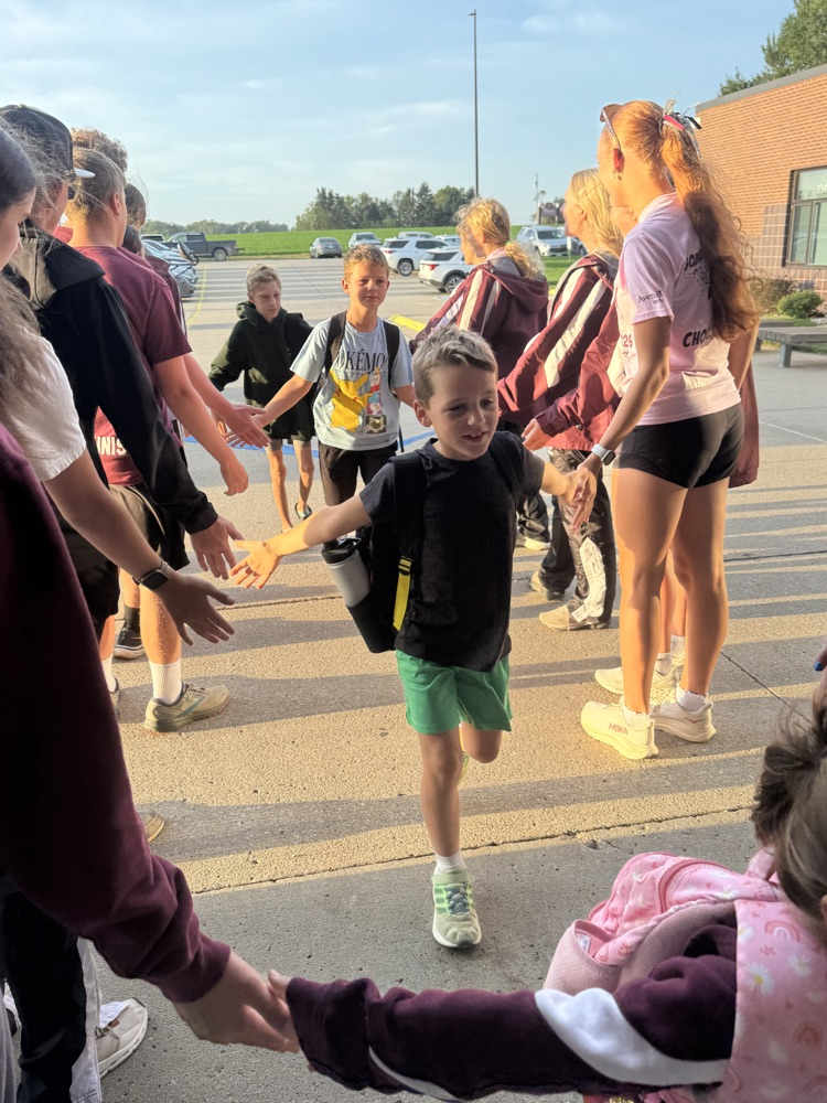 Cross Country team giving high fives to students at High Five Friday 