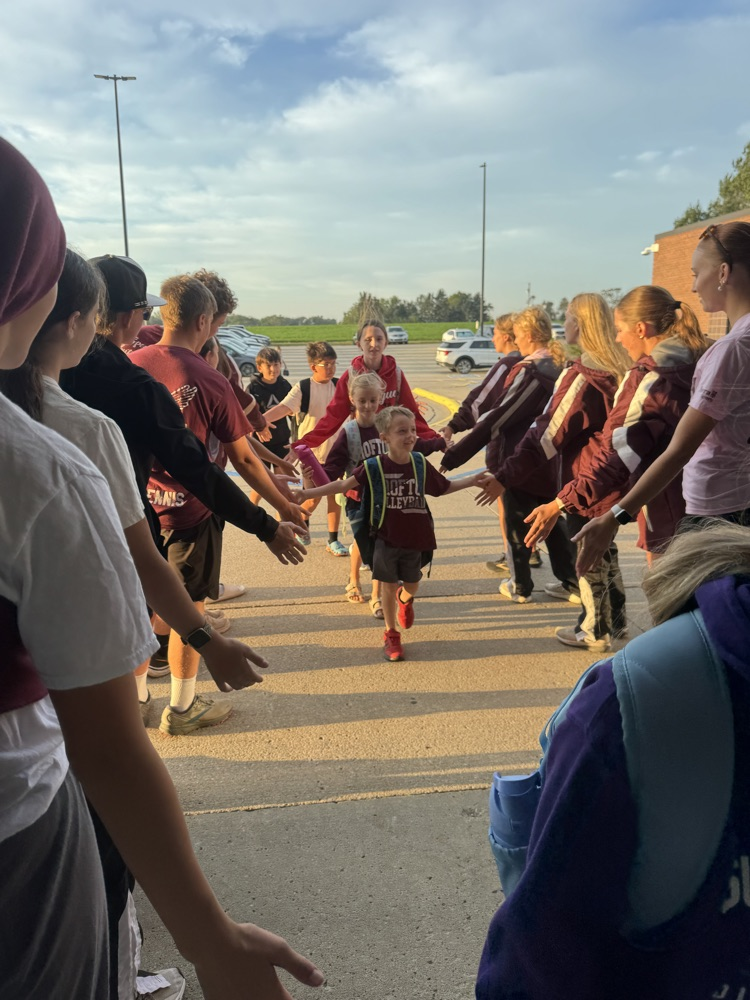 Cross Country team giving high fives to students at High Five Friday 