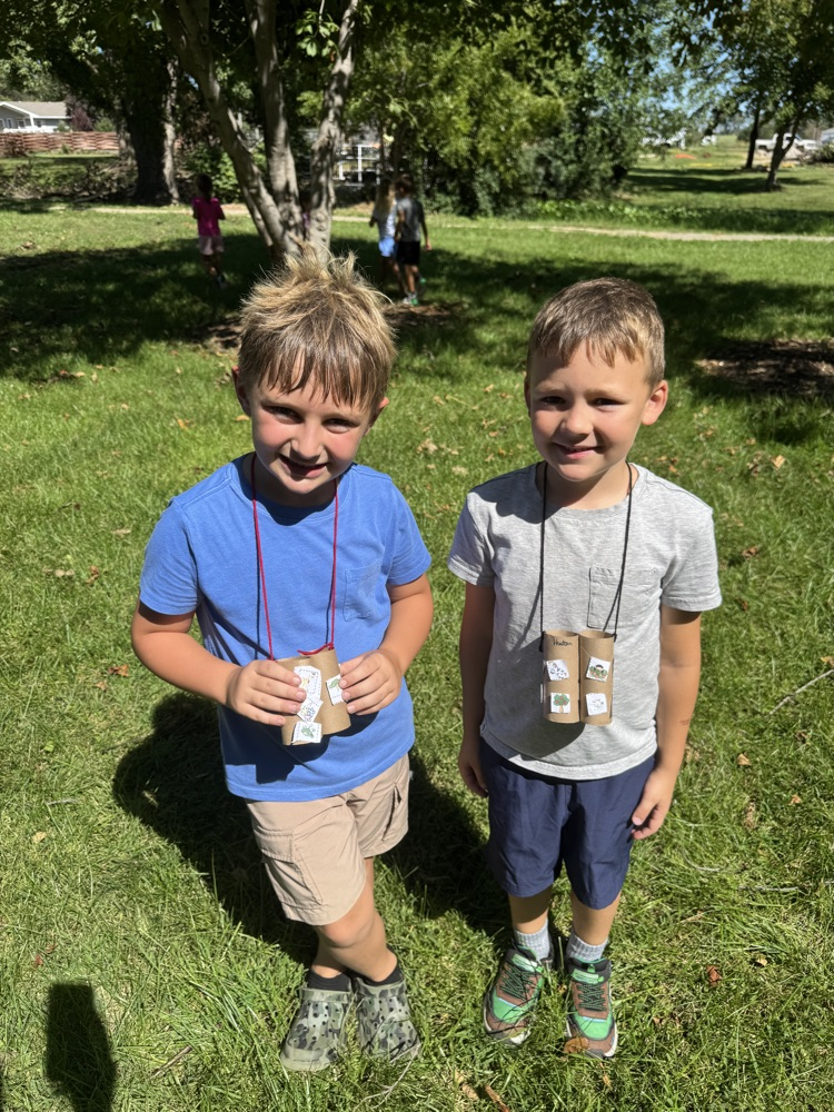 Kindergarteners using their binoculars to help them find living things at the park