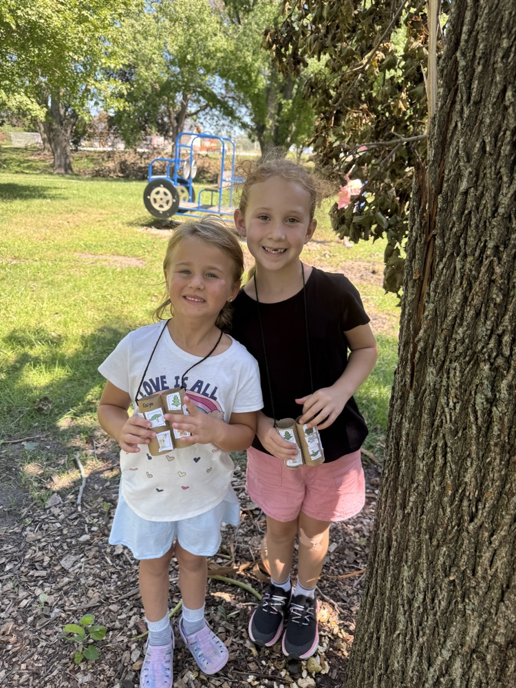 Kindergarteners using their binoculars to help them find living things at the park