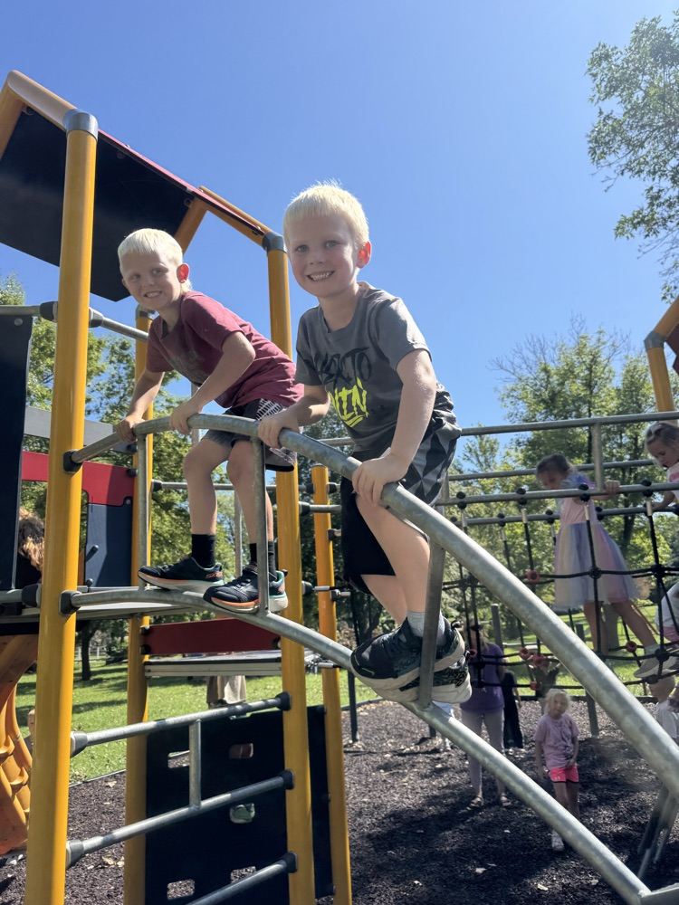 The work is done so now the kindergarteners are enjoying recess at the park on the monkey bars 