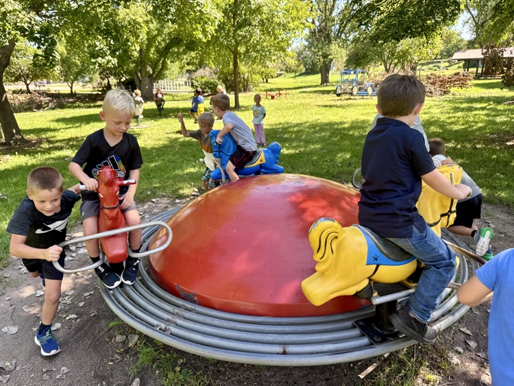 The work is done so now the kindergarteners are enjoying recess at the park on the horse merry-go-round!