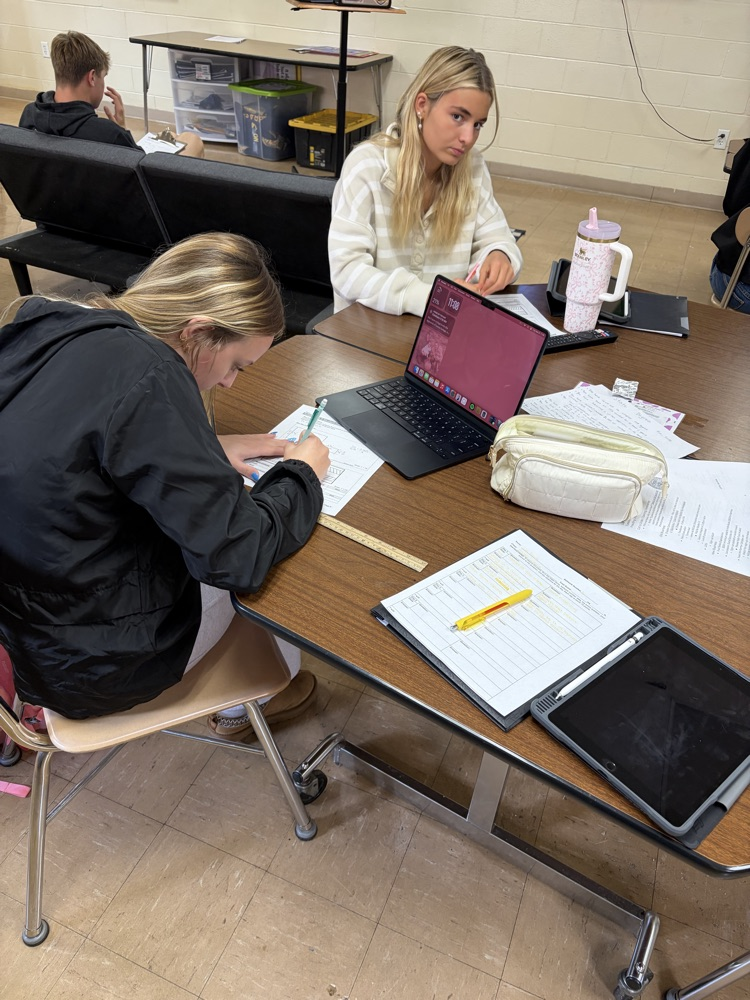 Students calculating facility size using scale measurements.