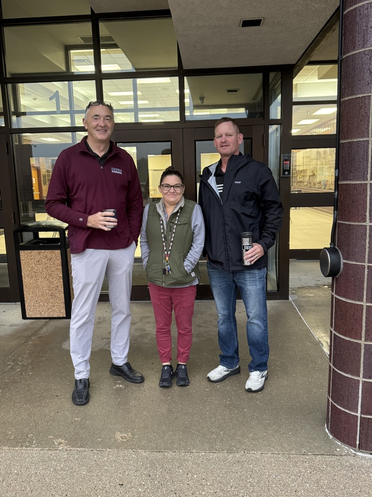 Administrators for High Five Friday standing outside greeting students