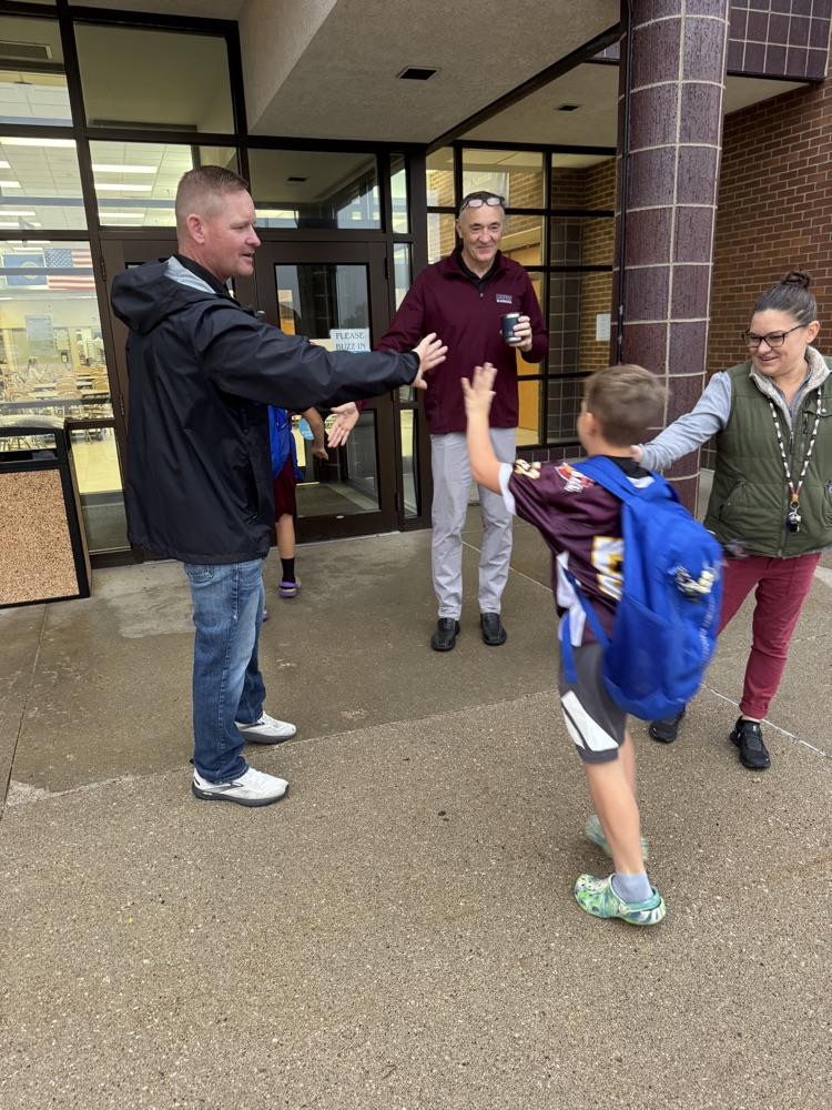 Administrators for High Five Friday standing outside greeting students
