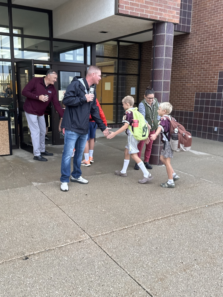 Administrators for High Five Friday standing outside greeting students