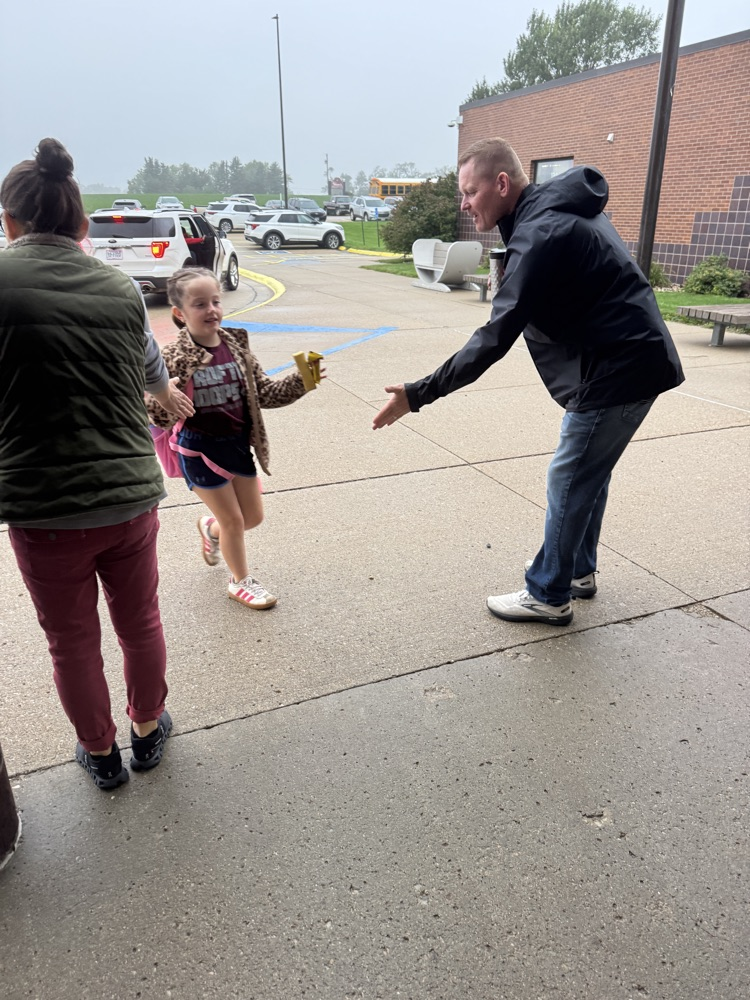 Administrators for High Five Friday standing outside greeting students