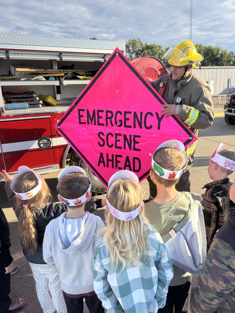 Students listening to a Crofton firefighter show them equipment on his fire truck 